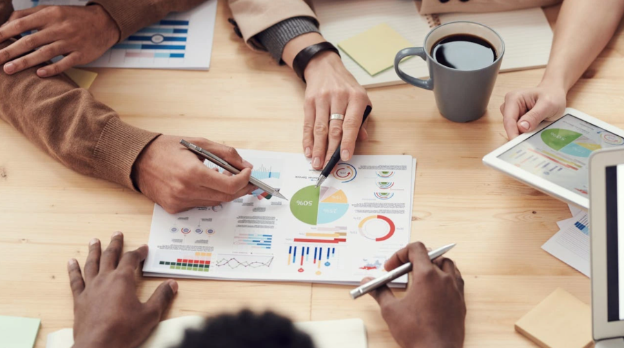 HR professional analyzing recruitment metrics on laptop with charts and graphs