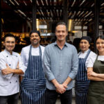 Owner with his staff at a restaurant.